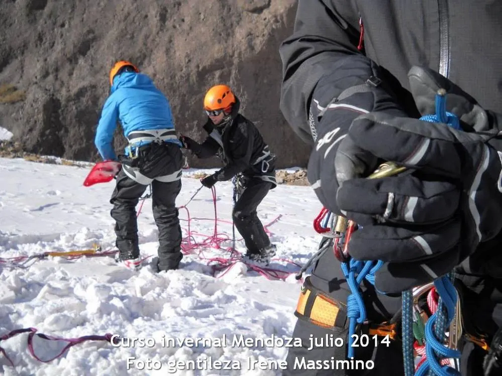 2 personas en un curso invernal ordenando la cuerda